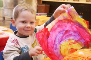 Child Holding Up Painting