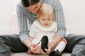 Mother Putting on Child's Shoes