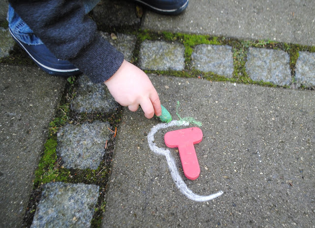 tracing letters in sidewalk chalk