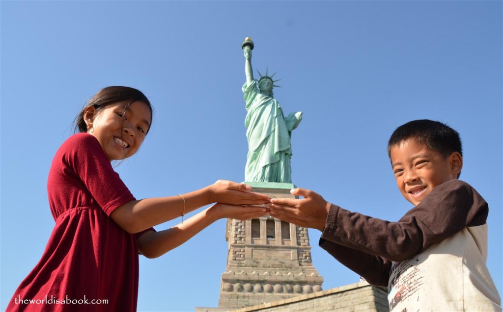 statue of liberty pose with kids in nyc