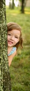 Girl Playing behind a tree